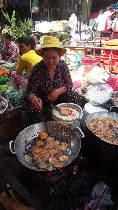 Local woman cooks traditional street food in Phnom Penh