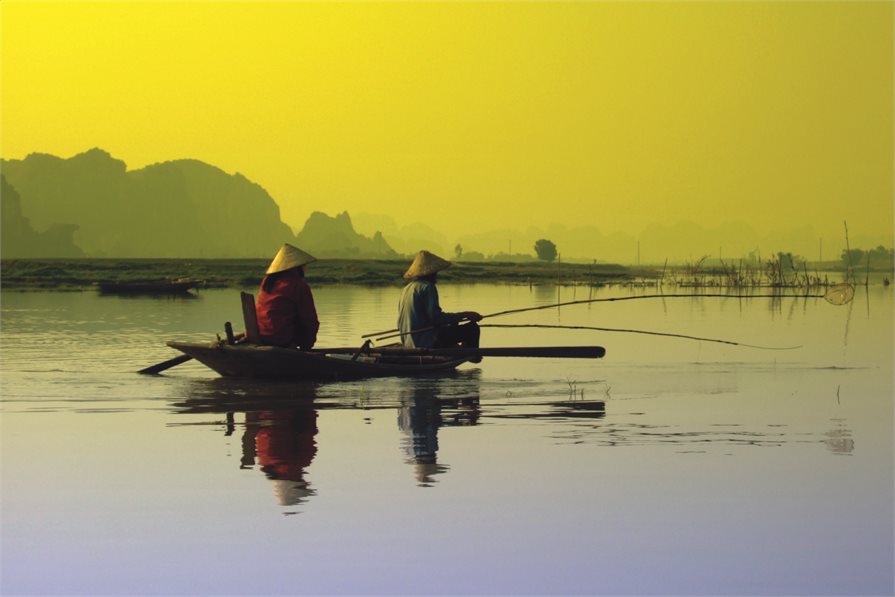 Fishermen on boat in Vietnam with Sun rise