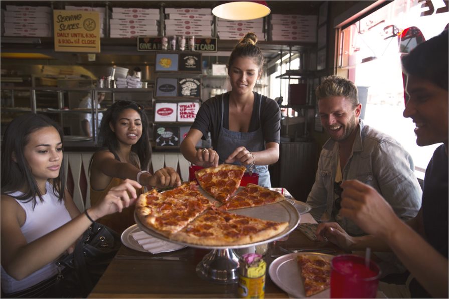 Group of people enjoying a Pepperoni Pizza